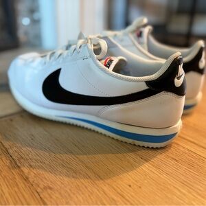 Nike Men's Cortez
White and Black Sneakers with Blue Accent